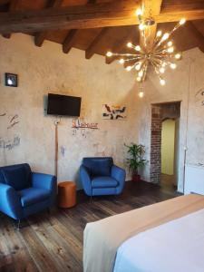 a bedroom with two blue chairs and a television at Casa Tonello B&B in Zugliano