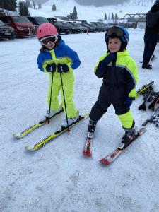 two young children are standing on skis in the snow at departamento familiar 2 in Malargüe