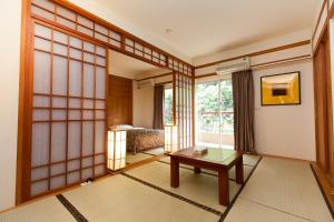 Zimmer mit einem Tisch, einem Bett und einem Fenster in der Unterkunft Hoya Hotel in Wenquan