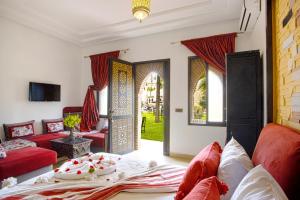 a living room with red furniture and an open door at Domaine Ghait in Had Abdallah Rhiat