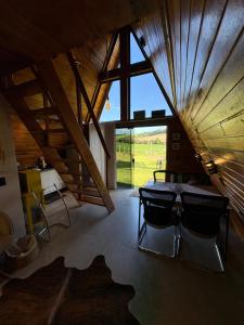 a room with a table and chairs and a large window at Sítio das Amoreiras- Cabana in Tabapira