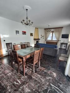 a living room with a table and chairs and a couch at Retica Tirano garage EV Station & Biliards BBQ e private Parking in Tirano