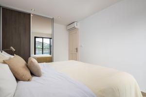 a bedroom with a large white bed with a mirror at Sunset Terrace Vinisce in Vinišće