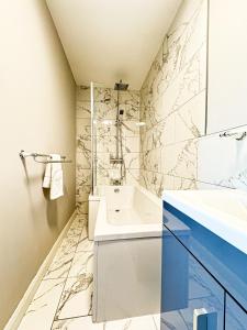 a bathroom with a white sink and a shower at Ocean View, 3 bed 2 bath, Dog Friendly, Private parking, Beach 9 min walk, sleeps 6 in Ilfracombe +18 photos
