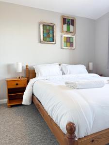a bedroom with a large bed and two windows at Ocean View, 3 bed 2 bath, Dog Friendly, Private parking, Beach 9 min walk, sleeps 6 in Ilfracombe