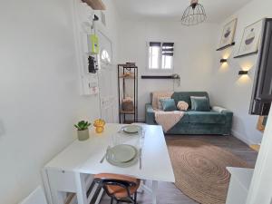 a living room with a white table and a couch at *Ça me convient* Studio Chaleureux in Villejuif
