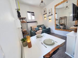 a living room with a white table and a couch at *Ça me convient* Studio Chaleureux in Villejuif
