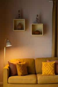 a yellow couch sitting in a living room with two shelves at Azorica Pico in Madalena +56 photos