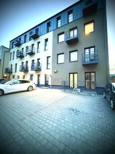 a building with two cars parked in front of it at Matas old town apartment in Kaunas