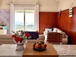 a living room with a table with flowers and fruit on it at HeenaluSurfCamp - ocean view appartement - 4P - Tamraght in Tamraght Ouzdar