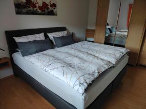 a bed with a white comforter and blue pillows at Ferienwohnung Siegel in Heimweiler
