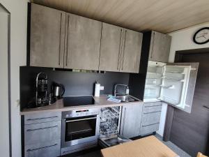 a kitchen with stainless steel cabinets and a refrigerator at Ferienwohnung Siegel in Heimweiler
