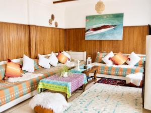 a living room with a couch and a table at HeenaluSurfCamp - ocean view appartement - 4P - Tamraght in Tamraght Ouzdar