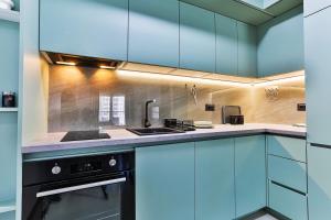 a kitchen with blue cabinets and a sink and a stove at Seaside Premium Apartments Bar - Susanj in Bar +24 photos