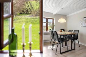 a dining room with a table and chairs and a window at LF11979-Struer-Havstokken-9-a in Vemb