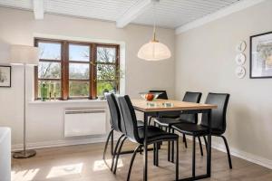 a dining room with a table and black chairs at LF11979-Struer-Havstokken-9-a in Vemb +11 photos