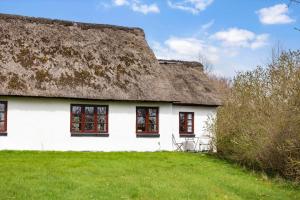 a white house with a thatched roof on a field at LF11979-Struer-Havstokken-9-a in Vemb