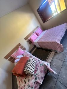 two beds in a room with pillows on the floor at Chalé do coiote! in São Roque de Minas