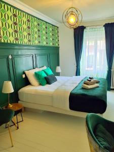 a bedroom with a large bed and a green wall at L'Insolite in Gorges