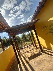 a wooden table sitting on a porch with a window at Chalé do coiote! in São Roque de Minas