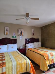 a bedroom with two beds and a ceiling at Hotel Milenio Nanacamilpa Tlaxcala in Nanacamilpa