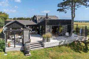 a house with a deck with a table and chairs at 20165-Samso-Marup-Bakkevej-14 in Mårup