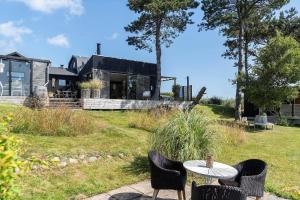 a table and chairs with a house in the background at 20165-Samso-Marup-Bakkevej-14 in Mårup +28 photos