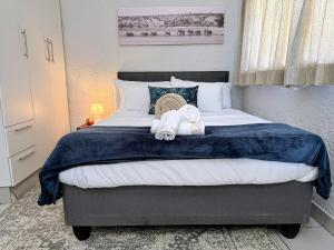 a bedroom with a large bed with towels on it at Signature Suite in Kempton Park +4 photos