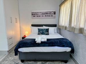 a bedroom with a bed with a teddy bear on it at Signature Suite in Kempton Park