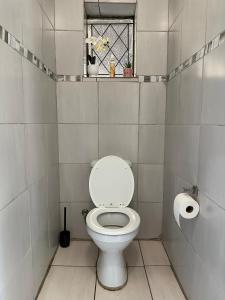 a small bathroom with a toilet and a window at Signature Suite in Kempton Park