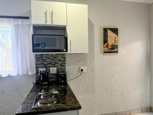 a kitchen with a stove and a microwave at Signature Suite in Kempton Park