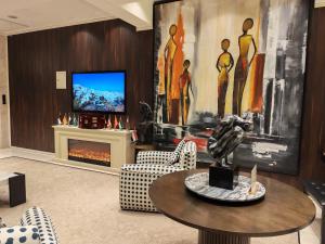 a living room with a table and a tv at Boutique Hotel in Baghdād