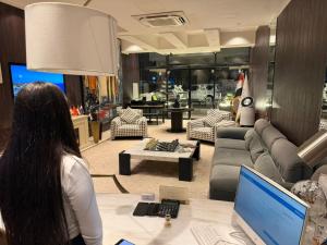 a woman standing at a table with a laptop in a store at Boutique Hotel in Baghdād