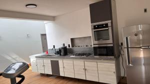 a kitchen with a refrigerator and a stove top oven at Quarto Personalizado Individual aconchegante novo no coração da cidade -Ufla- restaurantes e padaria in Lavras