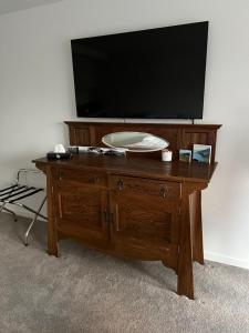 a wooden dresser with a television on top of it at Jacks Point Getaway in Queenstown Airport