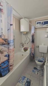 a bathroom with a bath tub and a toilet at William's Vendégház in Várpalota +11 photos