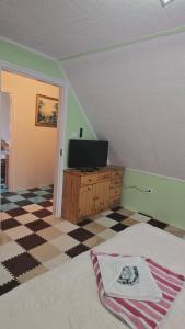 a bedroom with a bed and a tv on a dresser at William's Vendégház in Várpalota