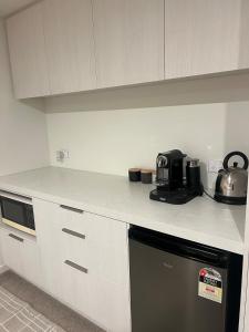 a kitchen with white cabinets and a counter top with a appliance at Jacks Point Getaway in Queenstown Airport