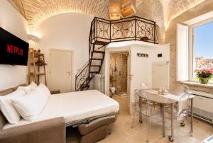 a bedroom with a large bed and a staircase at Martine Dimore Storiche di Puglia in Martina Franca