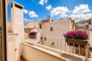 a balcony with purple flowers on a building at Martine Dimore Storiche di Puglia in Martina Franca
