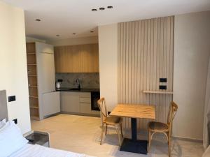a kitchen and dining room with a table and chairs at Ciel Apartement in Orikum
