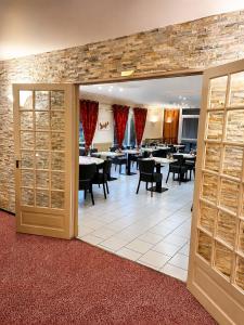 ein Esszimmer mit Tischen und Stühlen und einer Backsteinwand in der Unterkunft Logis Hotel Altina in Pacy-sur-Eure