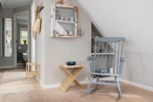 a blue rocking chair in a room with a staircase at 20430-Samso-Ballenvej-34A in Ballen