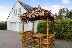 a table and two chairs and a thatch umbrella at 20430-Samso-Ballenvej-34A in Ballen