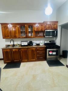 a kitchen with wooden cabinets and a stove top oven at Trelawnys Bliss Escape in Spring Rises