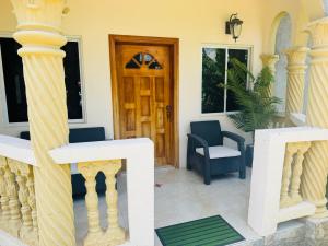 a house with a porch with a wooden door at Trelawnys Bliss Escape in Spring Rises