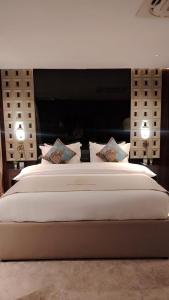 a large bed with two lights on top of it at Boutique Hotel in Baghdād