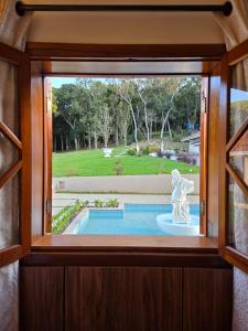 a window in a house looking out at a pool at The Winter Mountain Hotel in Monte Verde