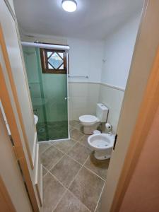 a bathroom with two toilets and a glass shower at The Winter Mountain Hotel in Monte Verde