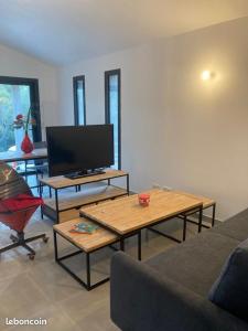a living room with a couch and a tv at Villa Vituli Corse-du-Sud entre Mer & Montagne in Figari